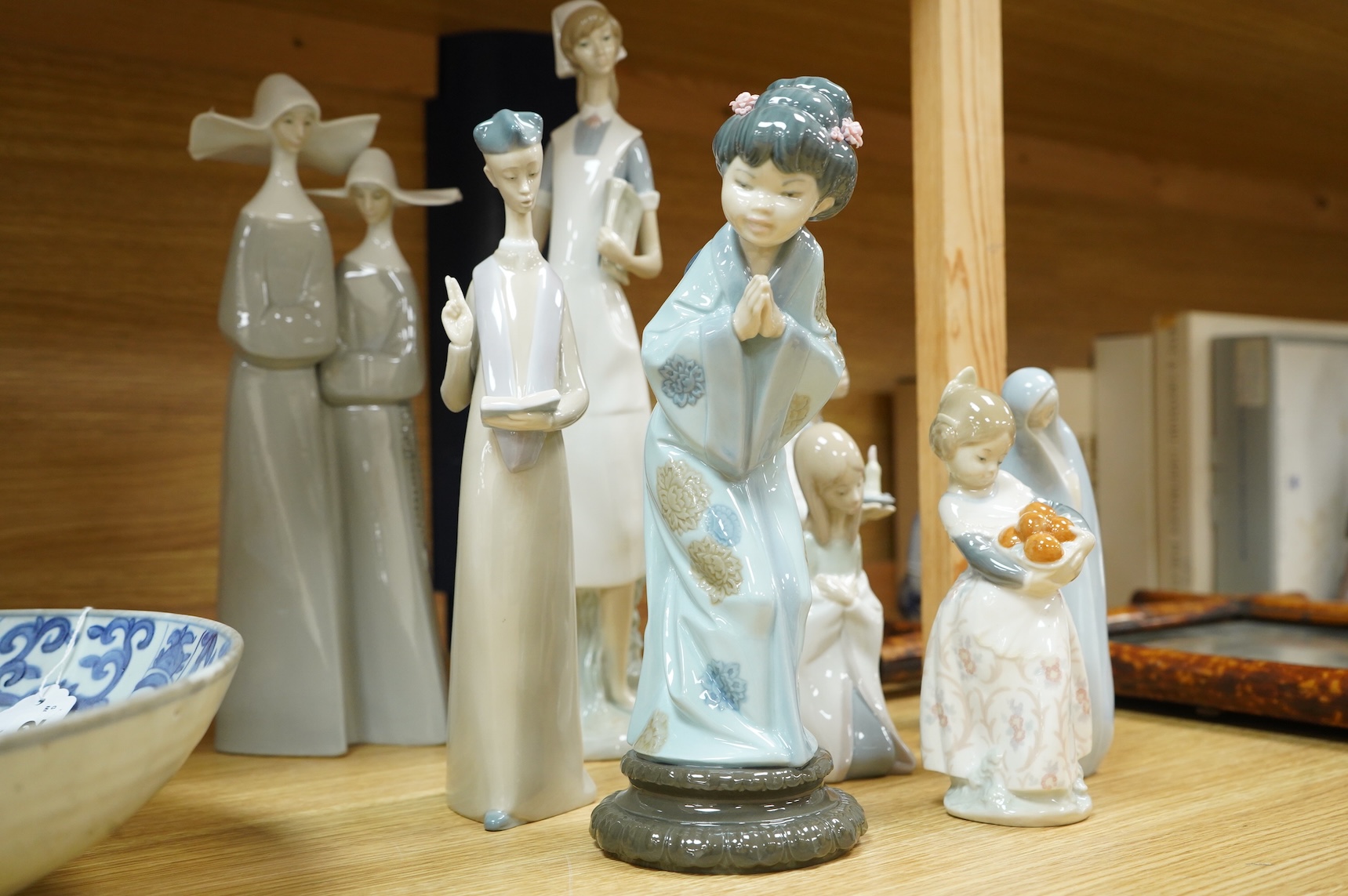 A group of Lladro figures - two Nuns, Geisha, Priest, Virgin Mary, Orange Girl with candle, Girl praying (8) tallest Nuns 33cm high